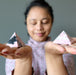 woman meditating with two rhodonite pyramids