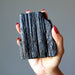 rough black tourmaline stone in hand