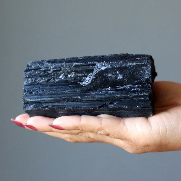 large rough black tourmaline stone in hand