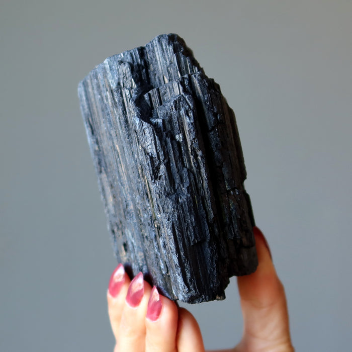 giant rough black tourmaline stone in hand
