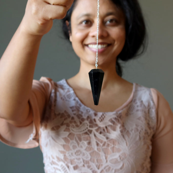 woman using black tourmaline faceted pendulum