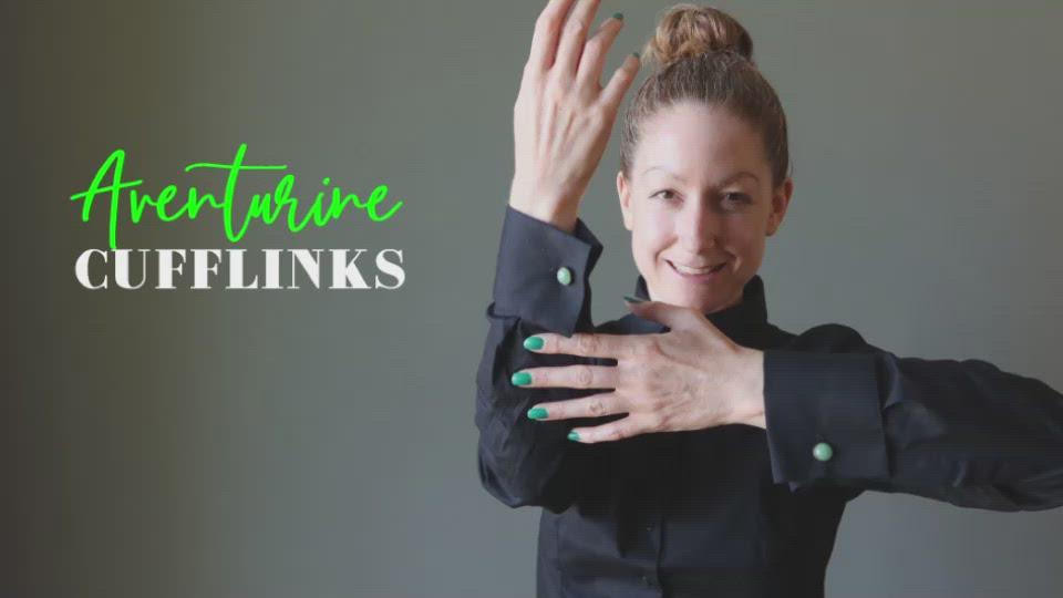 video with woman wearing black shirt with green cufflinks