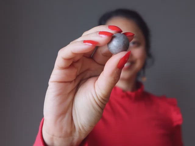 video featuring hand holding silver muonionalusta meteorite sphere 