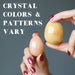 hands holding yellow aventurine eggs to show crystal colors and patterns vary