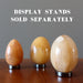 three yellow aventurine eggs on hematine ring stands which are sold separately