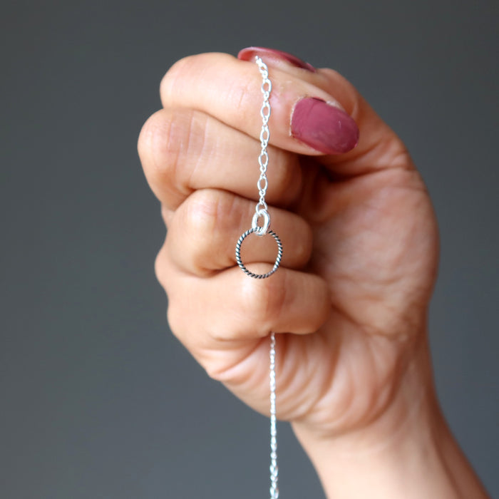 hand holding silver chain showing twist jumpring