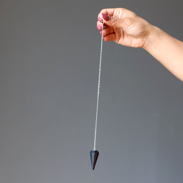 hand using shungite pendulum\