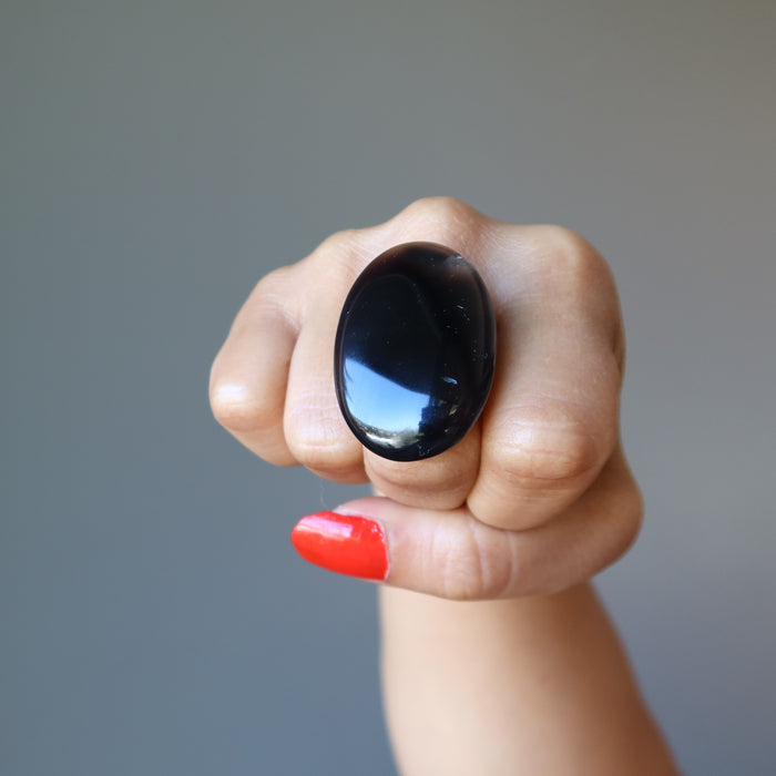fisted hand wearing large oval black agate ring