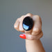 fisted hand wearing large oval black agate ring
