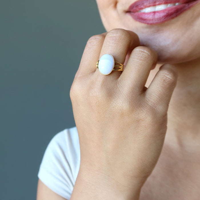 hand wearing blue lace agate oval in gold tone adjustable ring