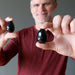 man holding two black agate eggs
