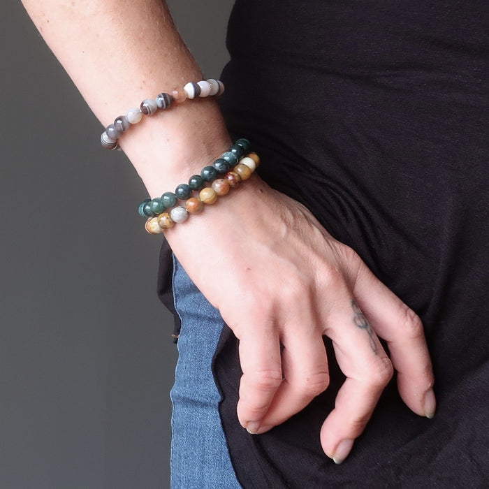 hand on hip wearing botswana, crazy lace and moss agate round beaded stretch bracelet set