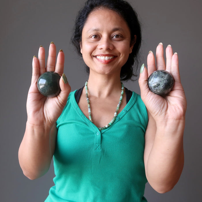 sheila of satin crystals holding moss agate spheres in each palm
