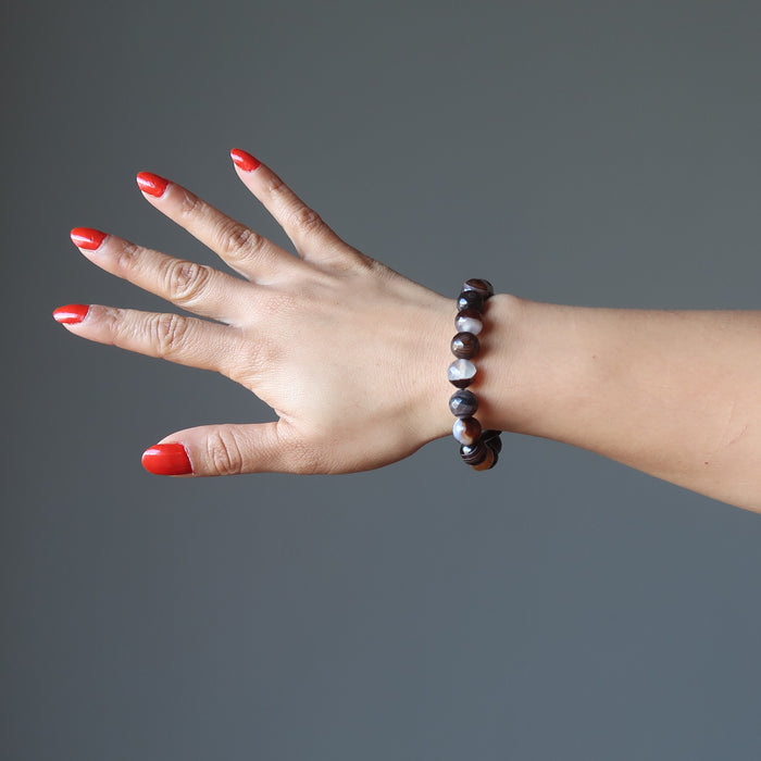 hand wearing banded coffee brown and black agate faceted round beaded stretch bracelets