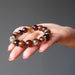 hand holding round coffee agate beaded stretch bracelet