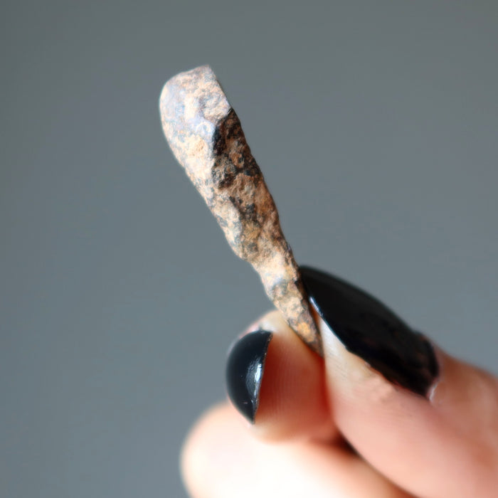 hand holding female holding agoudal iron meteorite finger
