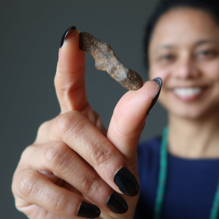 female holding agoudal iron meteorite finger
