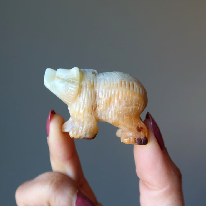 a model holding a light brown and green Amazonite Polar Bear Figurine