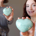 two female models holding light green Amazonite Heart Shiny Stones
