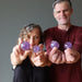 female and male models holding amethyst balls on each hand
