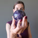 lucia of satin crystals holding up a Uruguay amethyst sphere with deep purple color