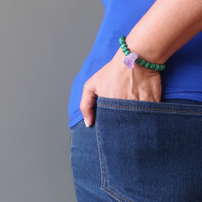 a model holds her hands to her jean pocket while wearing the custom designer Satin Crystals Malachite amethyst bracelet