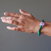 A male hand model displays the purple amethyst green malachite gemstone bracelet on his wrist