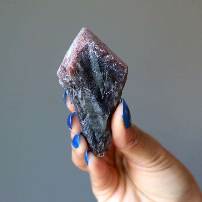 hand holding raw super 7 amethyst crystal point