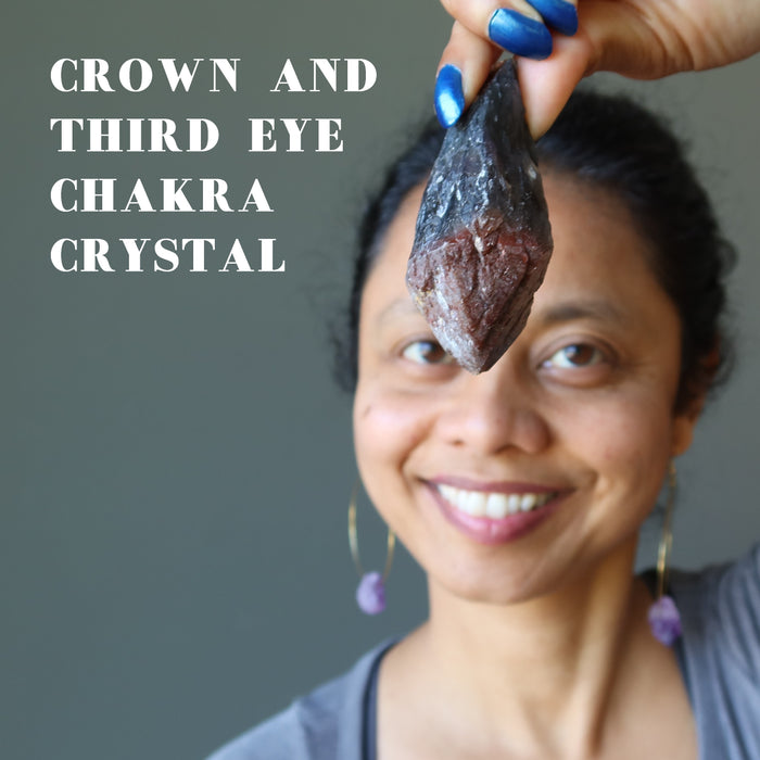 sheila of satin crystals holding raw super 7 amethyst crystal point over her crown and third eye chakra