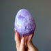 fingers are holding an amethyst egg