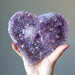 hand holding sparkling purple amethyst geode heart cluster