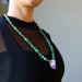sheila of satin crystal wearing The necklace made of raw purple Amethyst point  banded green Malachite and metal accent beads secured with a large lobster clasp