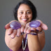 sheila of satin crystals holding pair of purple amethyst polished ovalish palm stones