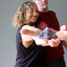 man and woman holding amethyst pyramids