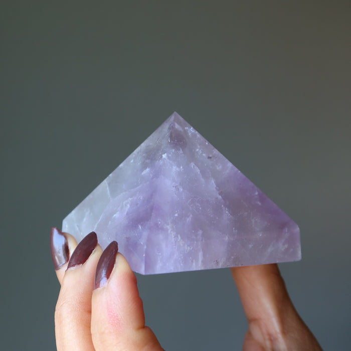 hand holding light purple amethyst pyramid