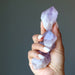 hand holding four raw purple amethyst points