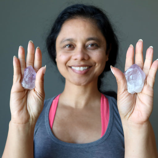 sheila of satin crystals holding two raw purple amethyst points in each hand