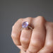 model wearing a faceted oval amethyst gemstone in silver ring