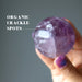 hand holding amethyst crystal ball showing organic crackle spots