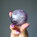 hand holding amethyst crystal ball