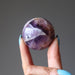 hand holding up a amethyst sphere
