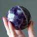 hand holding up a chevron amethyst sphere