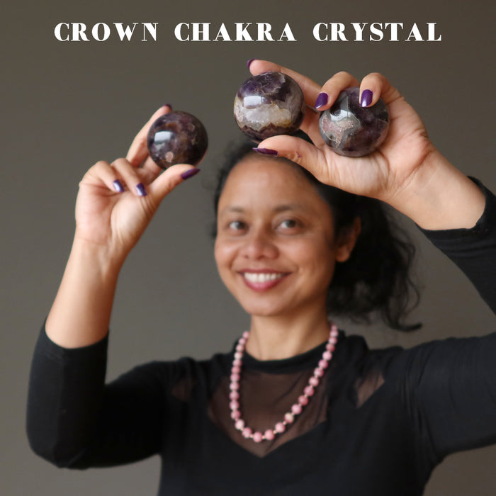 sheila of satin crystals holding three amethyst spheres at the crown chakra