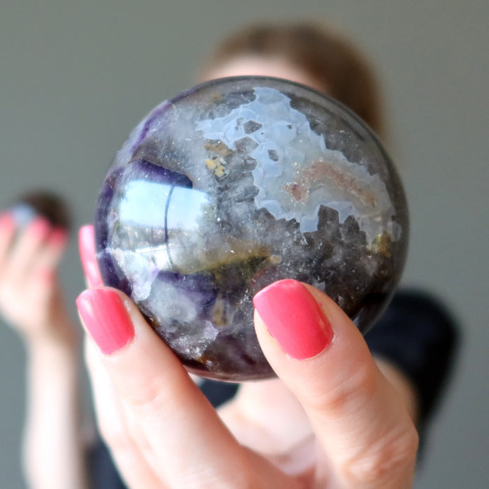 hand holding amethyst mineral mania sphere