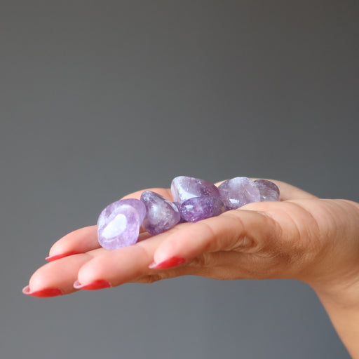 amethyst tumbled stones on a palm