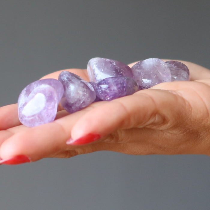 amethyst tumbled stones on a palm