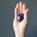 Model palm holding dark purple amethyst gemstone egg