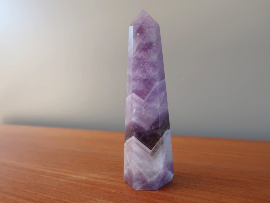 3.5-4 x 0.6 to 1 inches purple Amethyst Chevron crystal point tower Wand displaying on the table