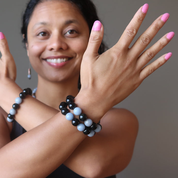 sheila of satin crystals wearing blue angelite and black rainbow obsidian stretch bracelets
