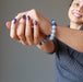 female with hands extended wearing lapis angelite bracelets on each wrist
